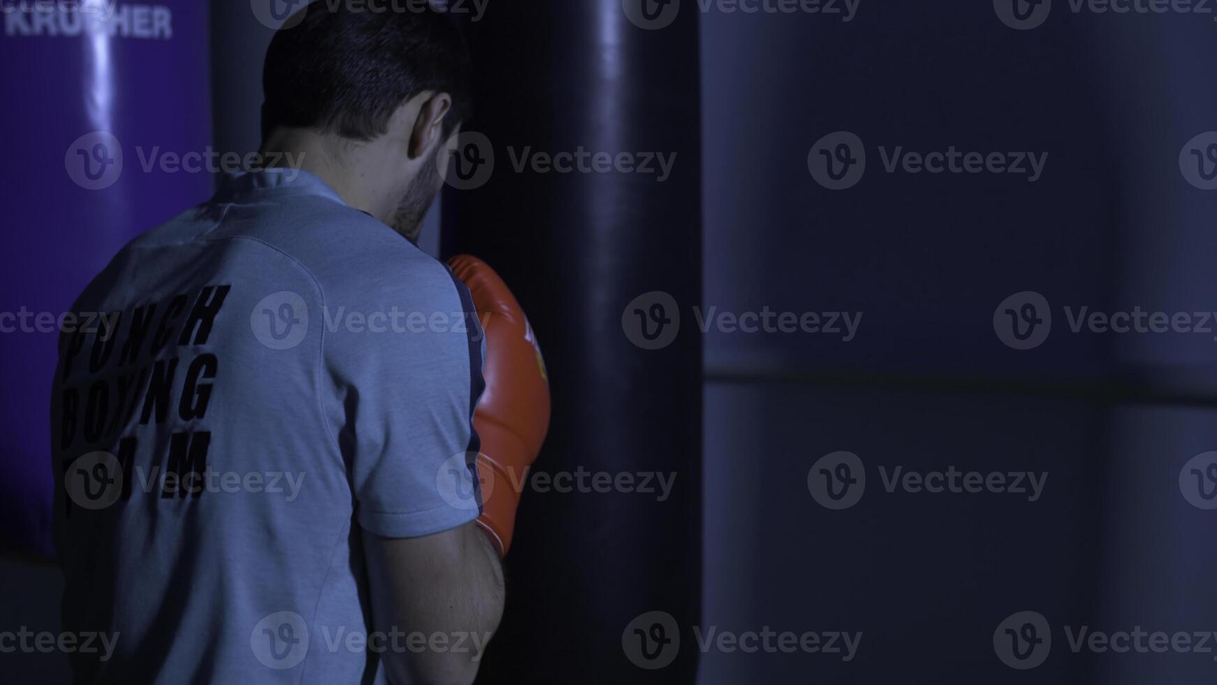 açao do uma boxe marcial artes lutador Treinamento em uma soco saco dentro a academia. boxer Treinamento com soco saco foto