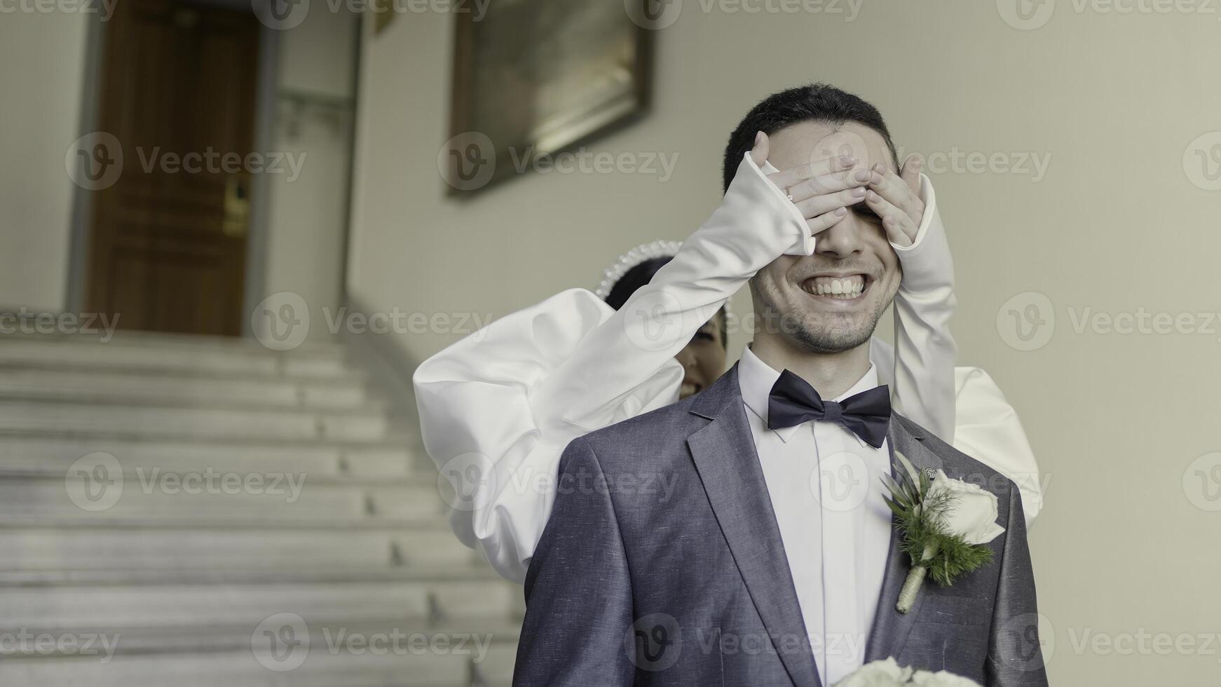 uma casal do a noiva e noivo paquera com cada outro. Ação. sorridente recém-casados filmando dentro uma construção com brilhante iluminação e decorações. foto