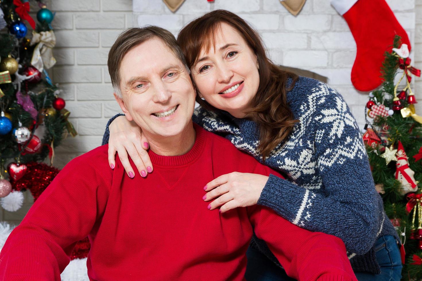 Natal retrato de casal de meia-idade na frente da árvore de natal, amoroso celebração de família, ano novo, pessoas de férias foto