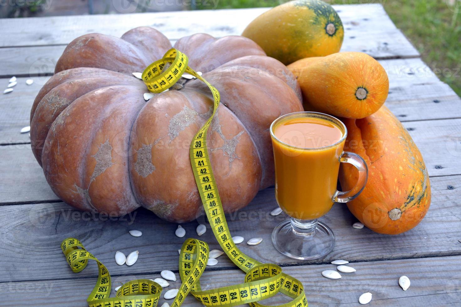 suco de abóbora dieta. enorme abóbora em um fundo de madeira. foto