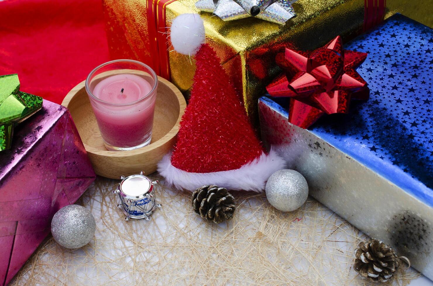 chapéu de natal e vela com fundos de decoração de caixa de presente foto