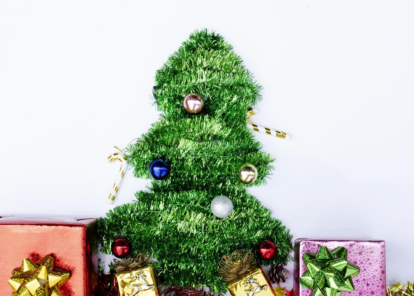 decoração de árvore de natal e caixa de presente plana sobre fundos brancos foto