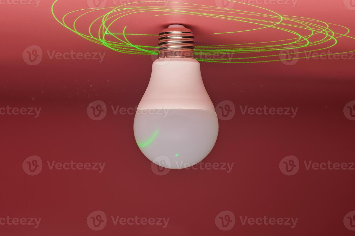 lâmpada e feixe de laser verde ao redor, economia de energia. conceito de ideia mínima. foto