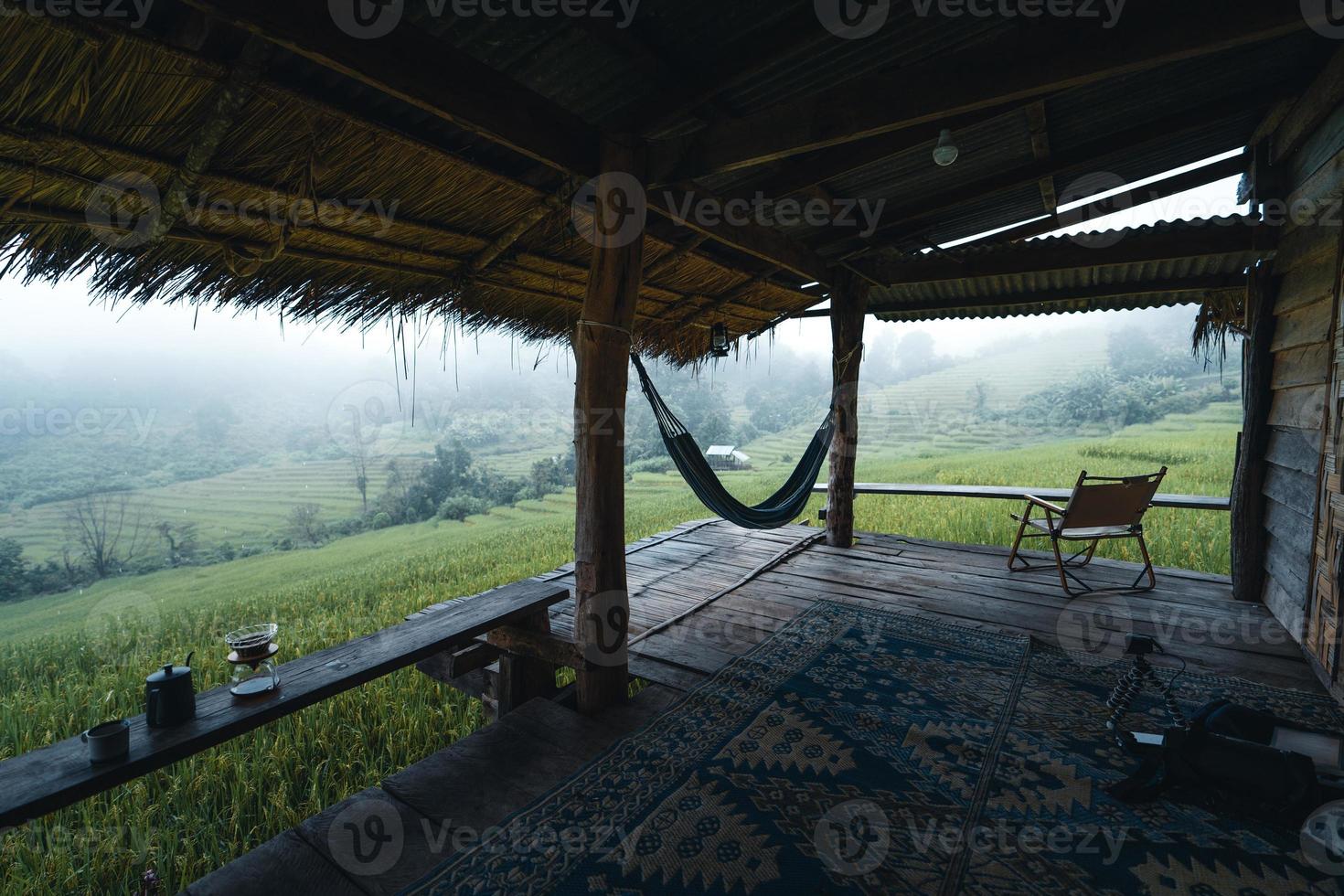 em uma cabana de madeira em um campo de arroz verde foto