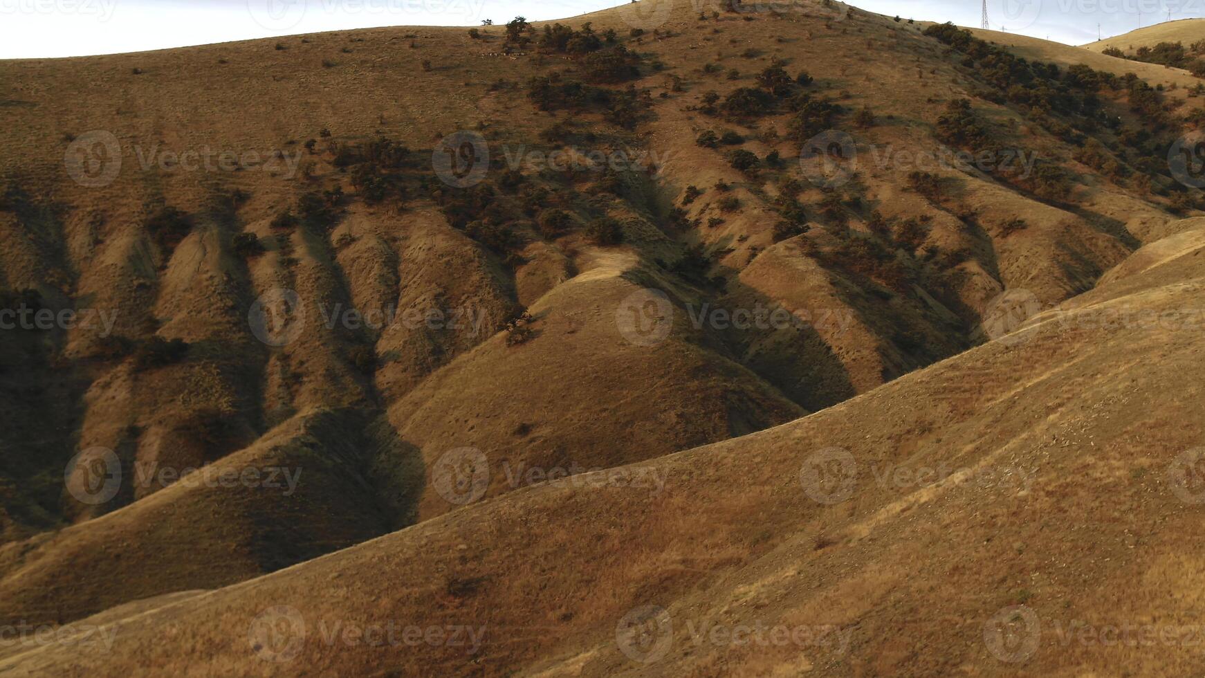 lindo Visão do vermelho colinas coberto com arbustos contra a Claro azul céu dentro ensolarado dia. tomada. surpreendente colorida panorama foto