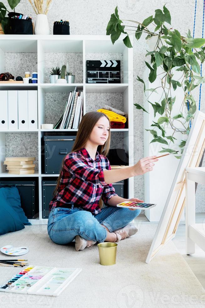 bela mulher artista pintando um quadro em casa foto