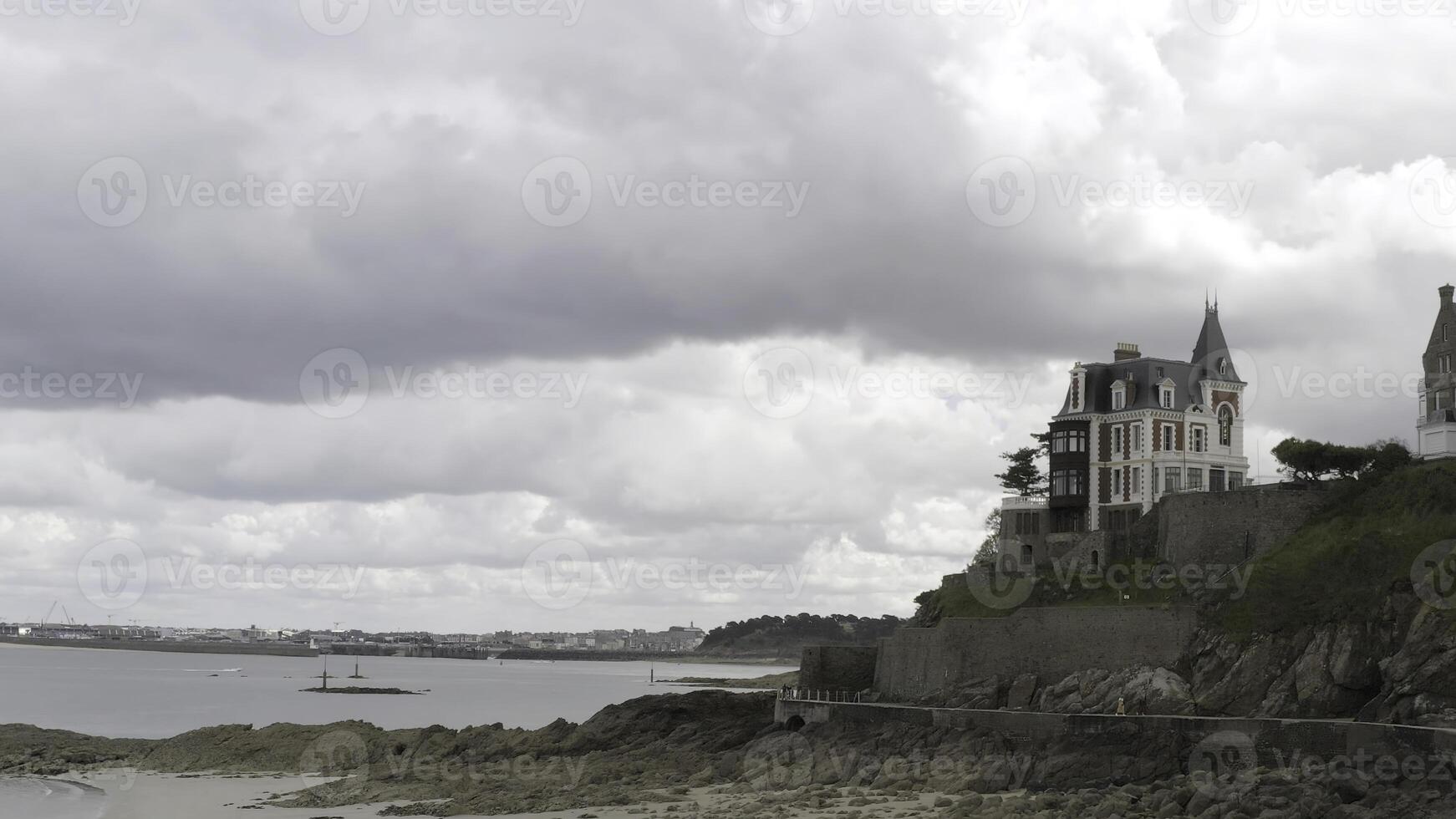 panorâmico aéreo Visão do a chalés do branco e vermelho tijolos localizado em a borda de a mar costa. Ação. lado Visão do a tijolo casas perto a costa linha em nublado céu fundo. foto