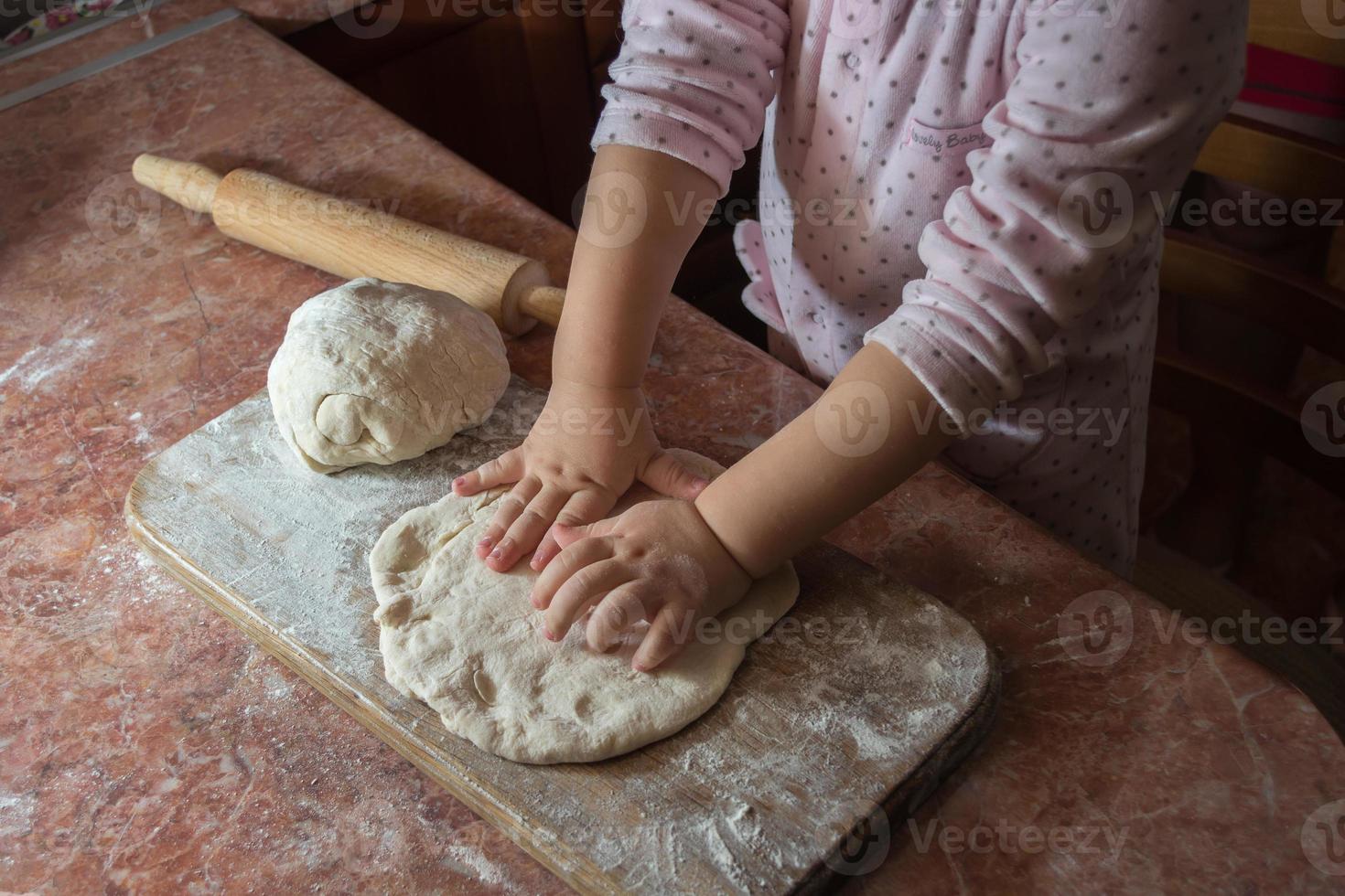 criança fazendo pizza foto