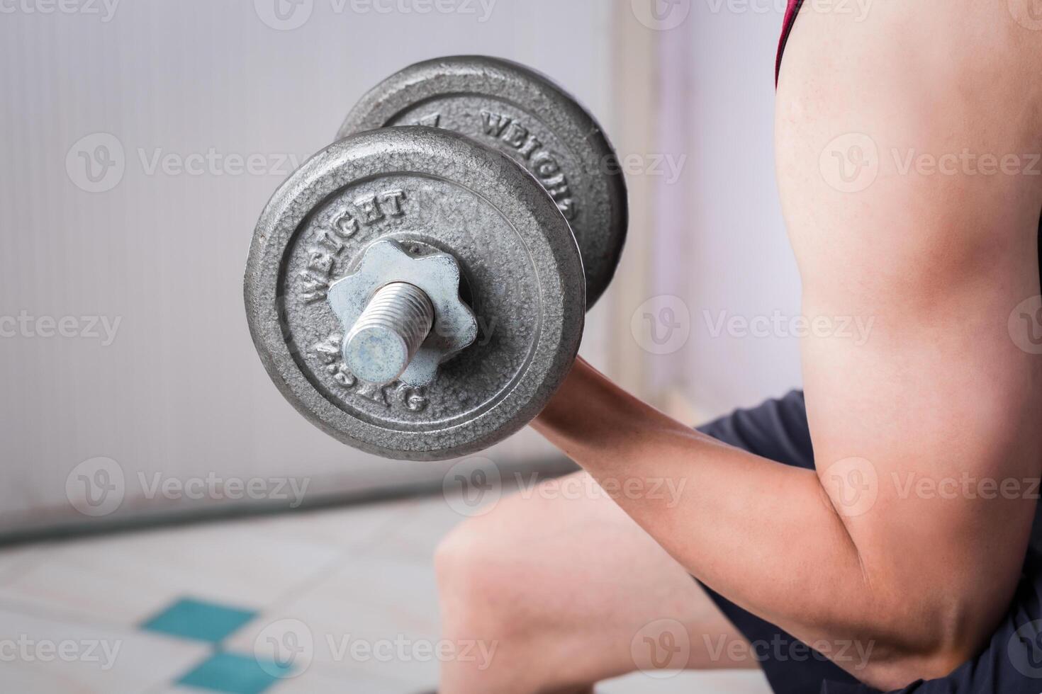 homem mão Treinamento elevação haltere Forte musculação. foto