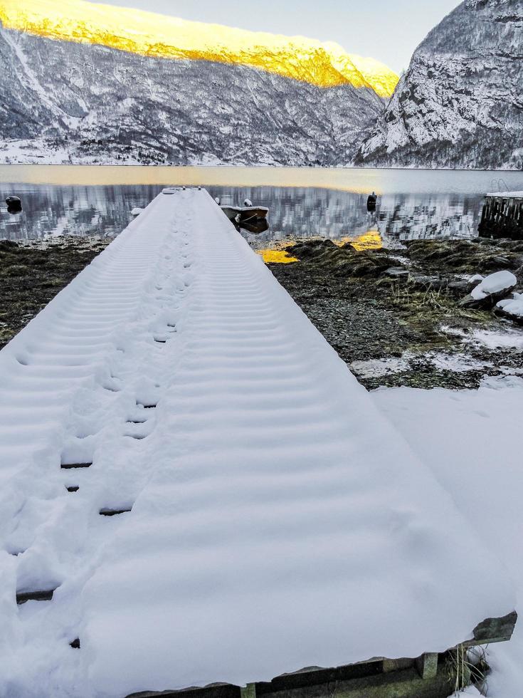 paisagem de inverno do cais coberto de neve no lago fiorde na Noruega. foto