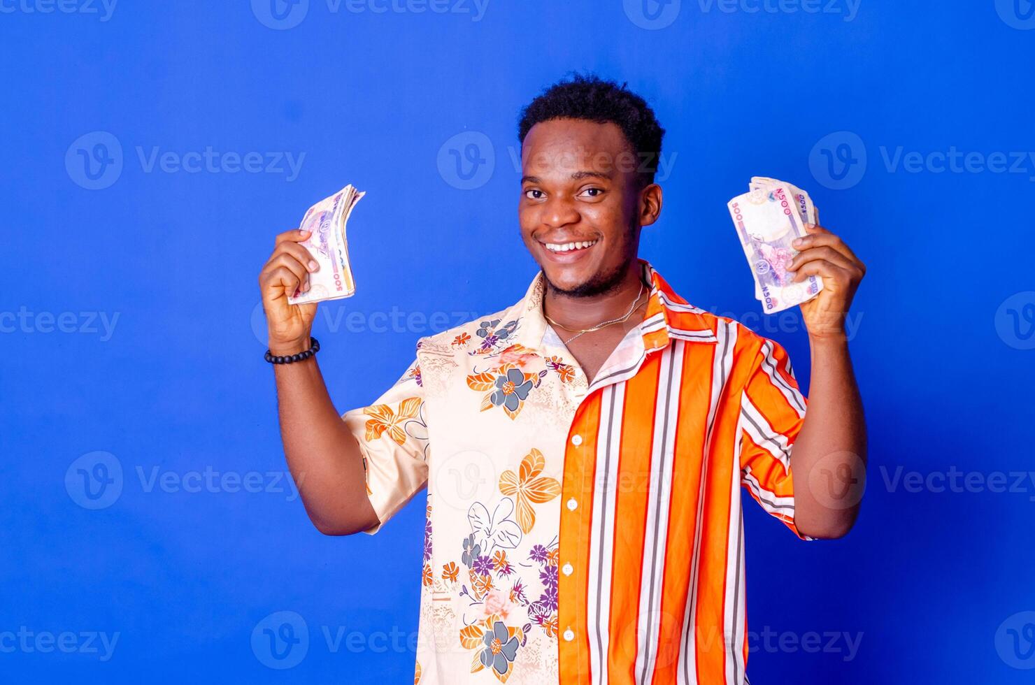 feliz e animado jovem africano homem segurando Pacotes do dinheiro foto