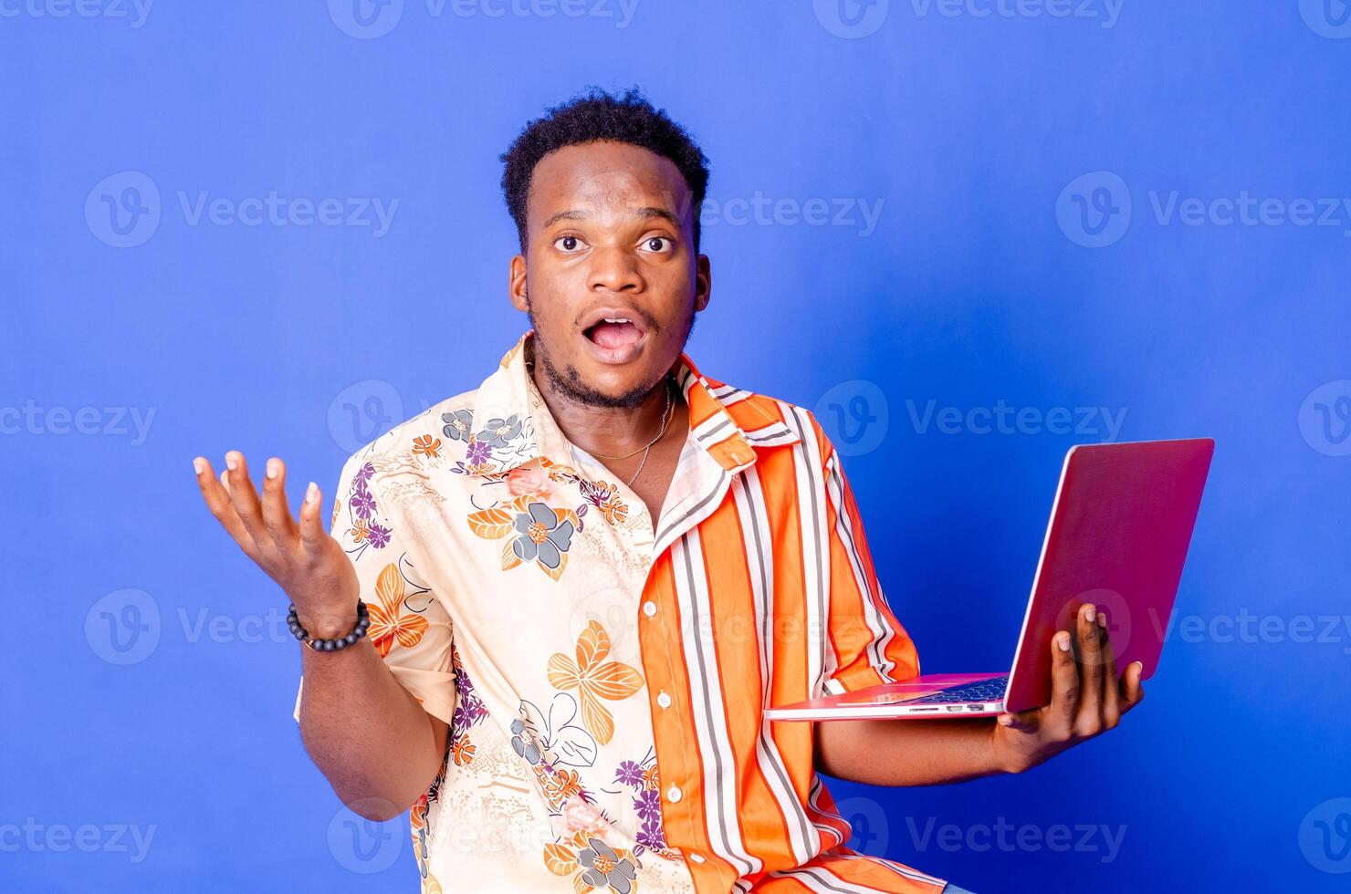 retrato do jovem moderno homem de negocios em pé segurando computador portátil e olhando às Câmera com feliz sorrir foto