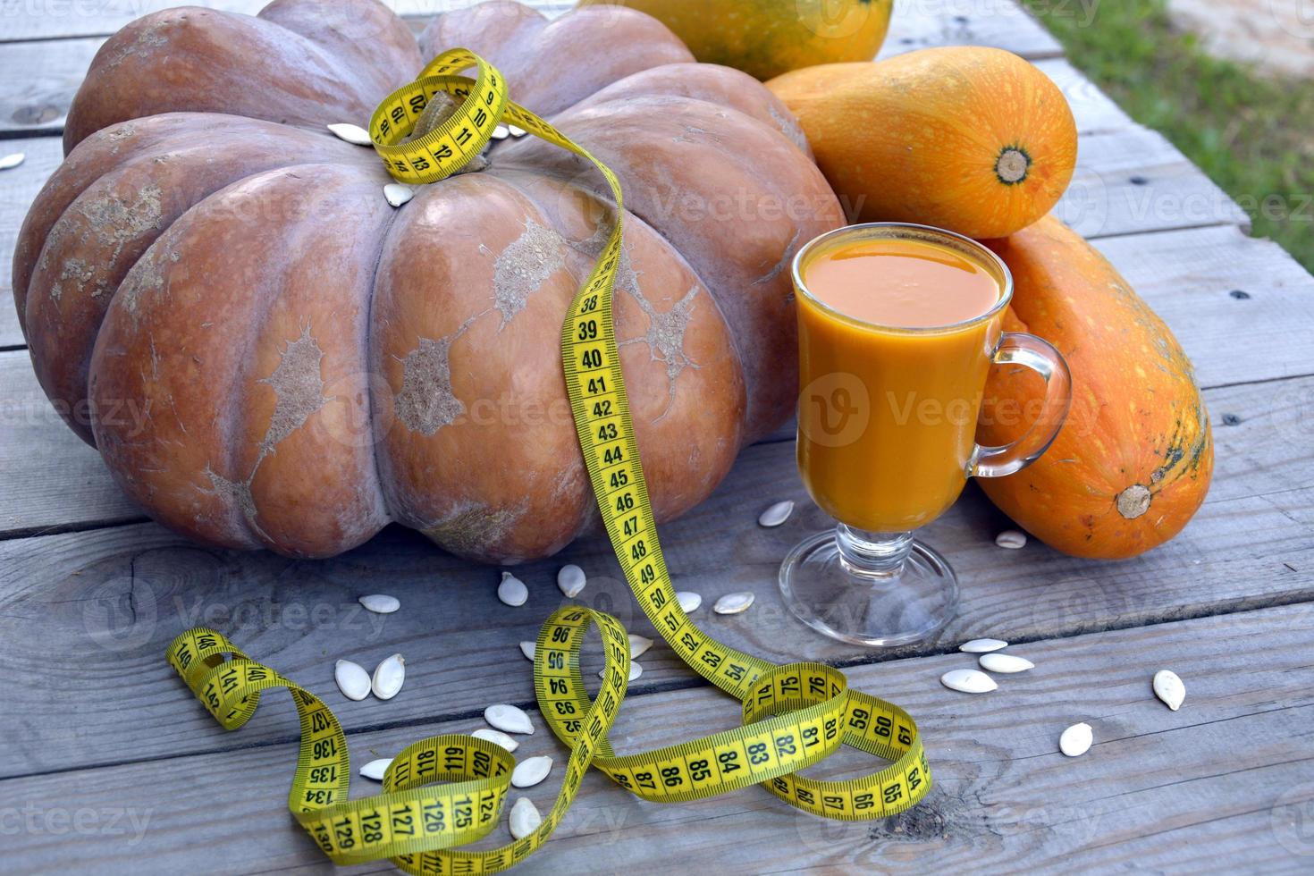 suco de vegetais da dieta. enorme abóbora e abobrinha em um fundo de madeira. foto