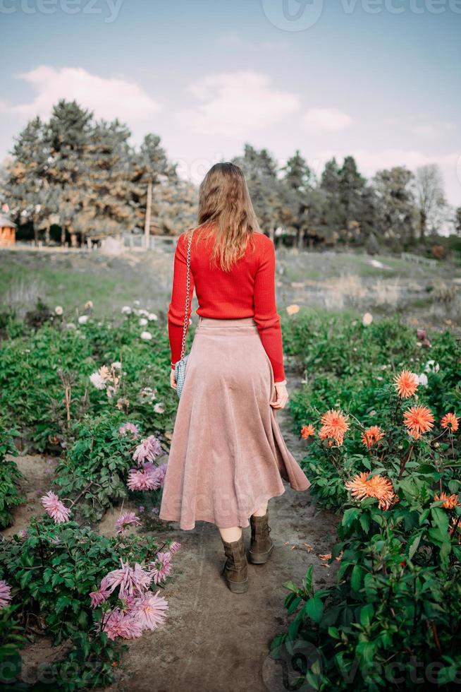 garota em um vestido vermelho em um campo floral foto