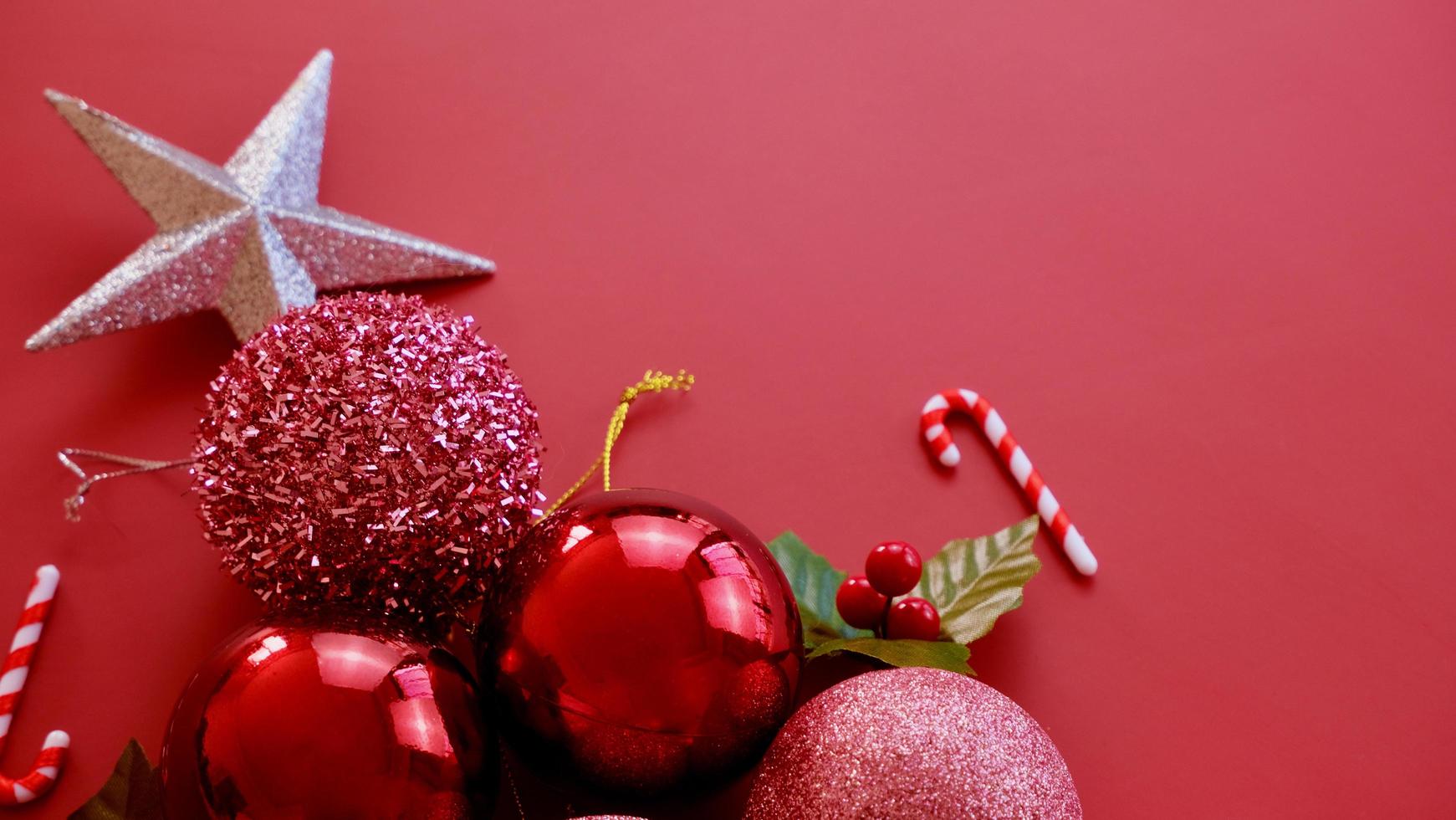 decorações de natal, estrelas brilhantes, bolas vermelhas, flocos de neve em fundo vermelho foto