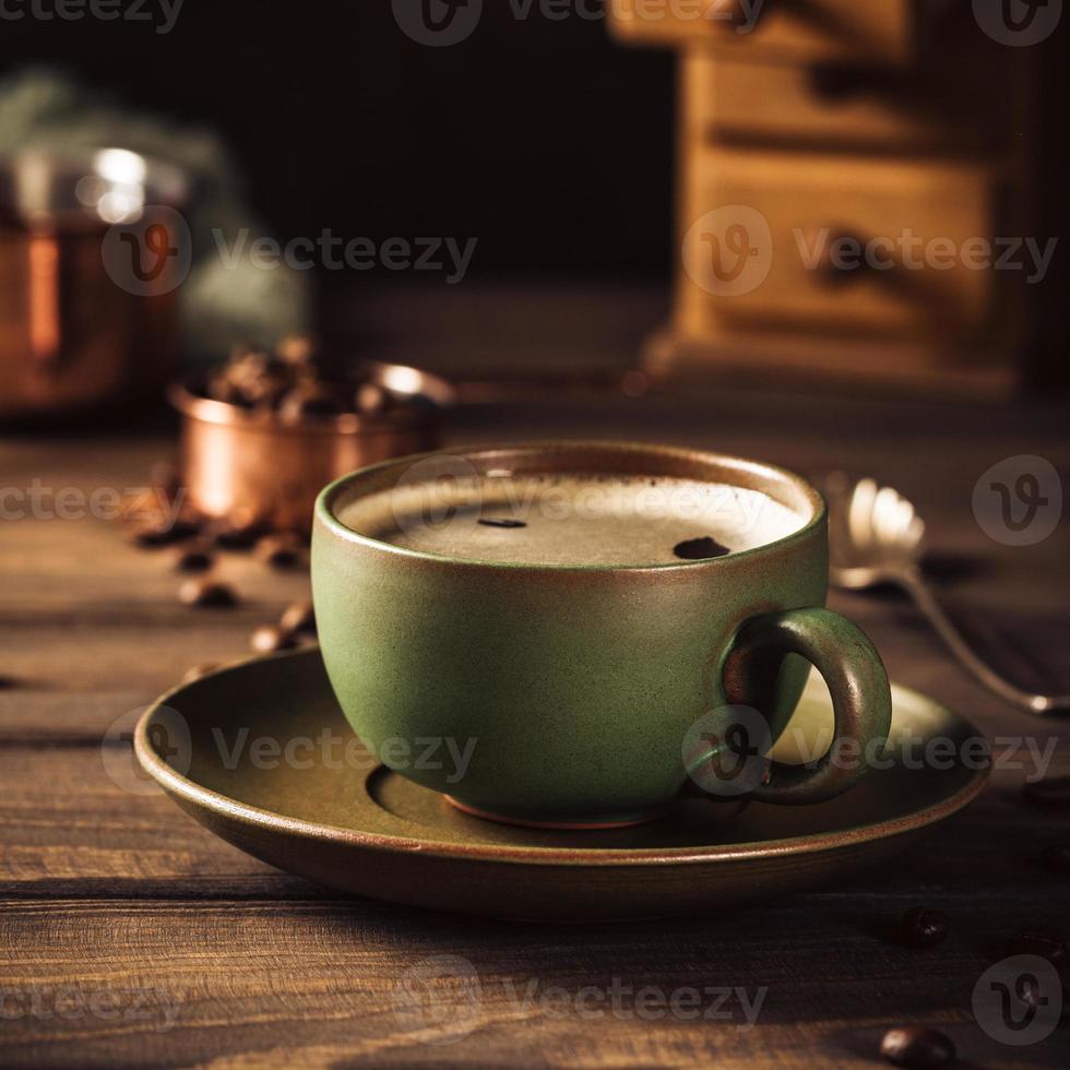 xícara de café verde com moedor de café foto