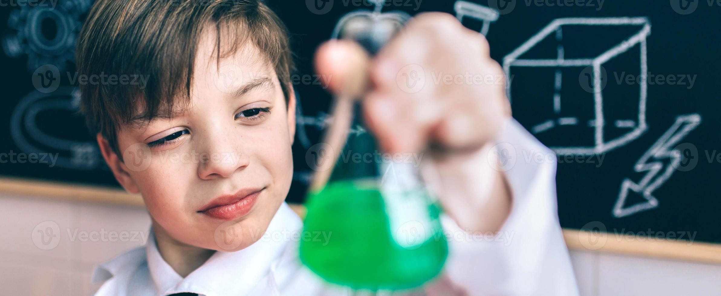 garoto sério procurando frasco com líquido químico foto