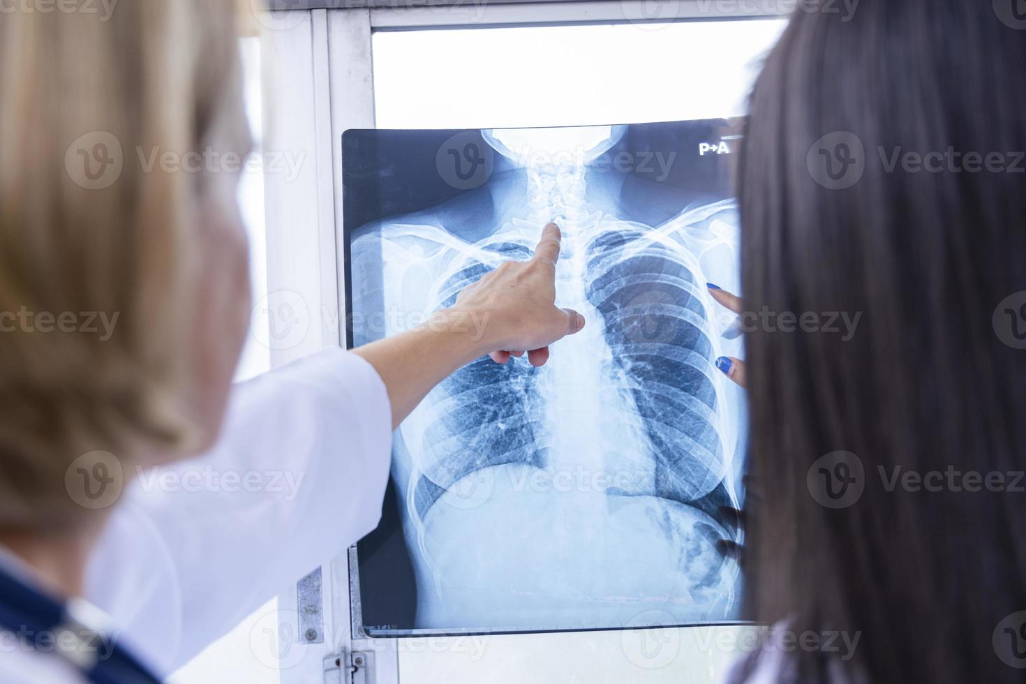 mulher médico sênior ensinando mulher estudante doutor. como analisar o filme de raio-x. departamento de radiologia foto