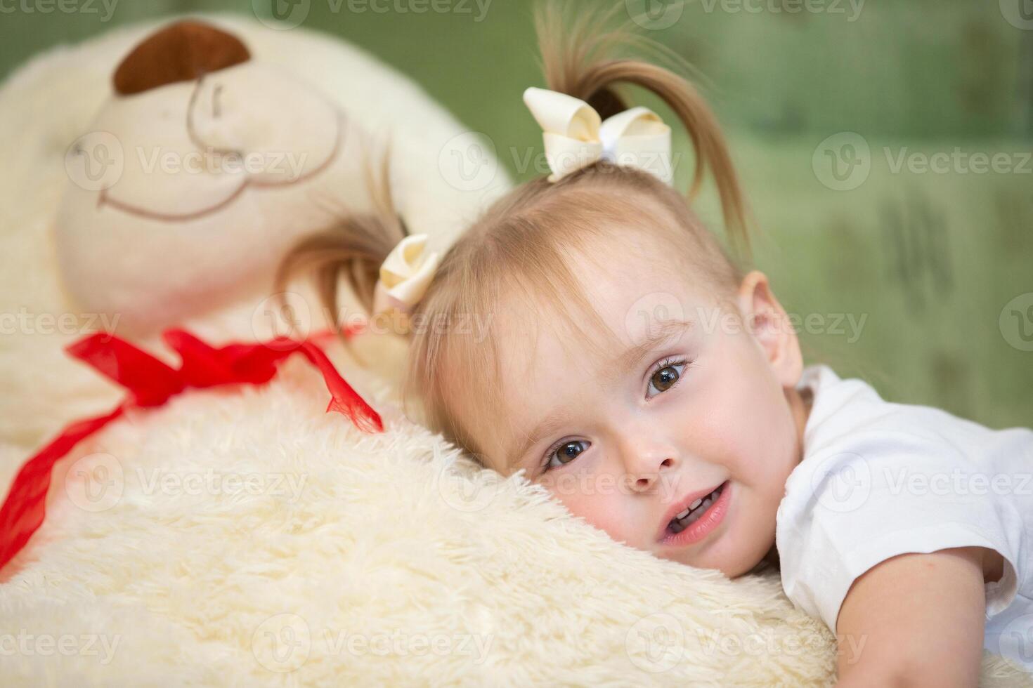 pequeno menina posando com uma fofo brinquedo às lar. foto