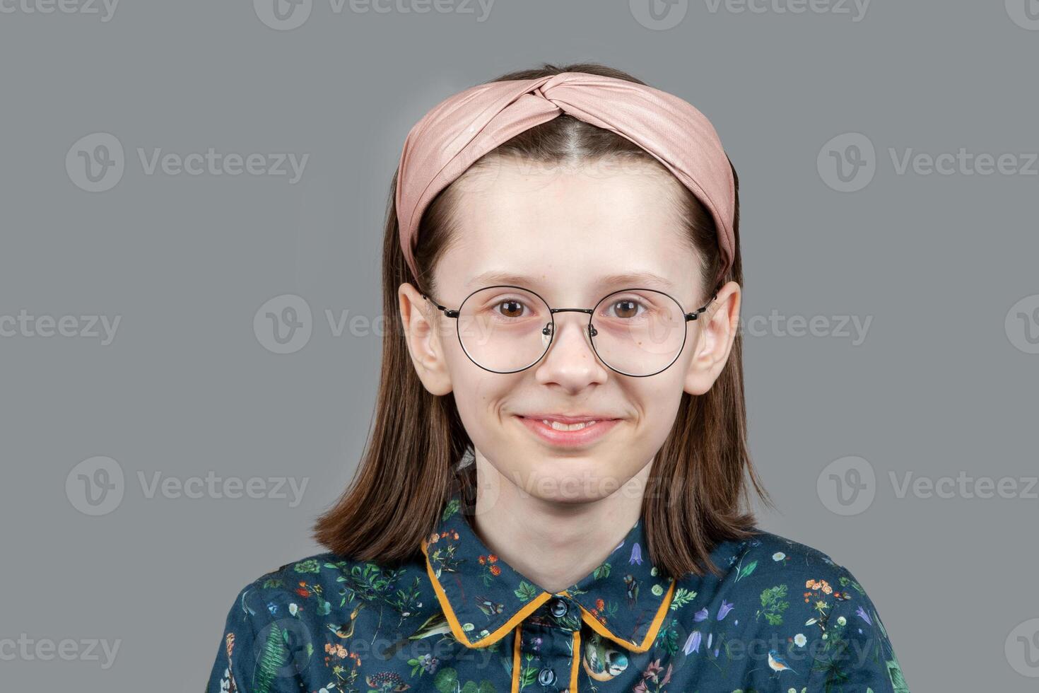 engraçado menina com óculos parece às a Câmera e sorri. uma inteligente, bem lido, memorizado criança com pobre visão. foto