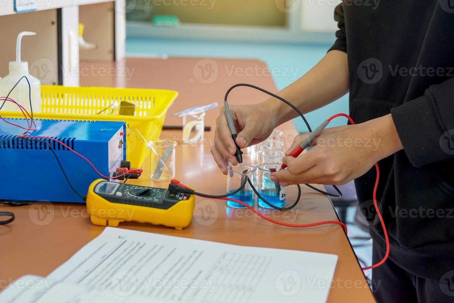 alunos a medida elétrico atual de experimentando com criando uma galvânico célula, que é a eletroquímico célula este usa uma químico reação para produzir a elétrico atual. foto