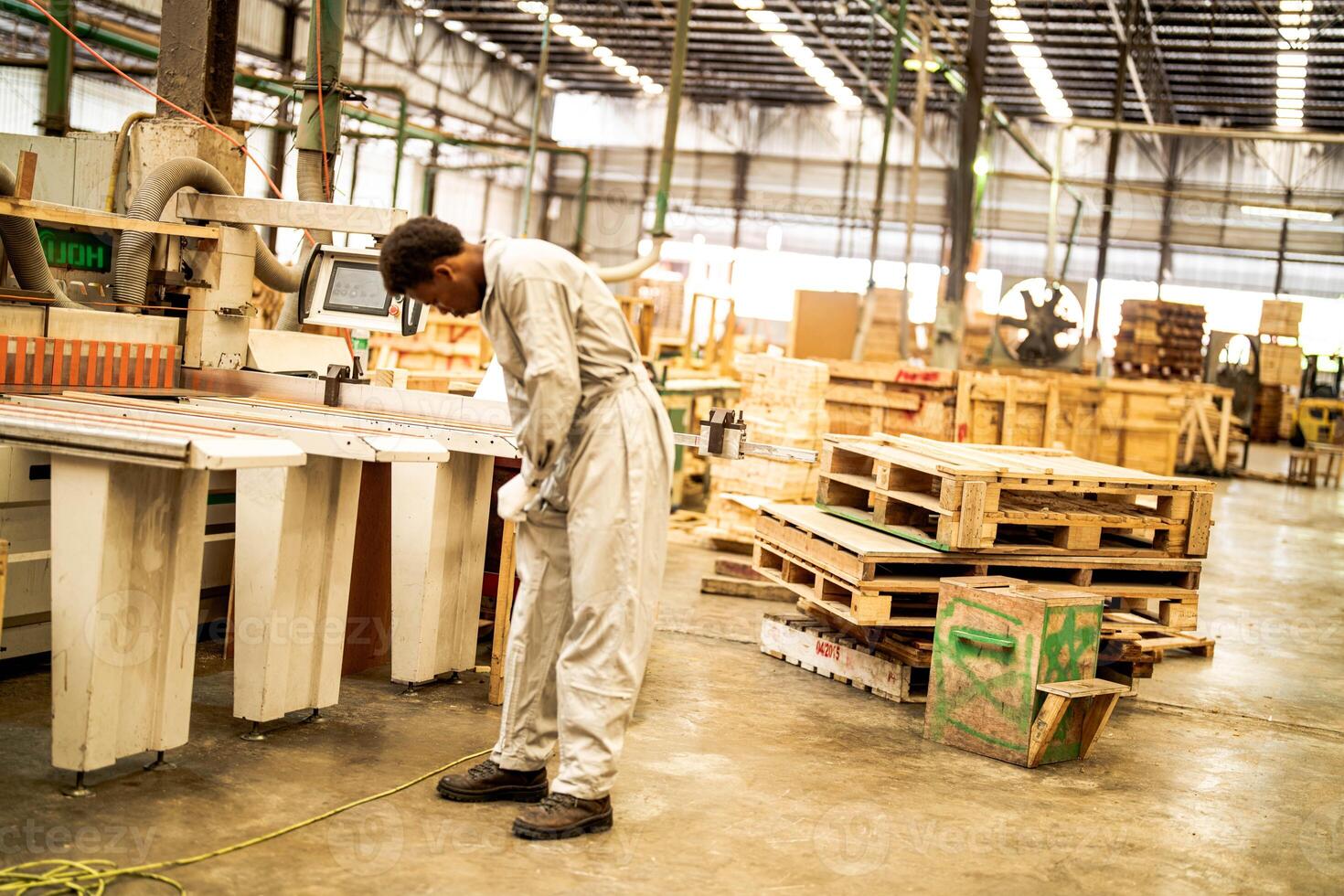 africano homem trabalhadores Engenharia em pé com confiança com trabalhando suíte vestir e mão luva dentro frente máquina. conceito do inteligente indústria trabalhador operativo. madeira fábrica produzir madeira palato. foto