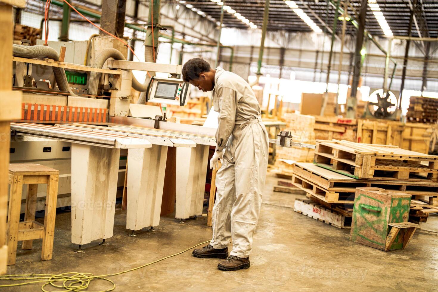 africano homem trabalhadores Engenharia em pé com confiança com trabalhando suíte vestir e mão luva dentro frente máquina. conceito do inteligente indústria trabalhador operativo. madeira fábrica produzir madeira palato. foto