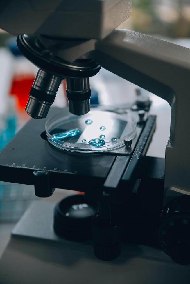 equipe de cientistas de pesquisa bioquímica trabalhando com microscópio para desenvolvimento de vacina contra coronavírus em laboratório de pesquisa farmacêutica, foco seletivo foto