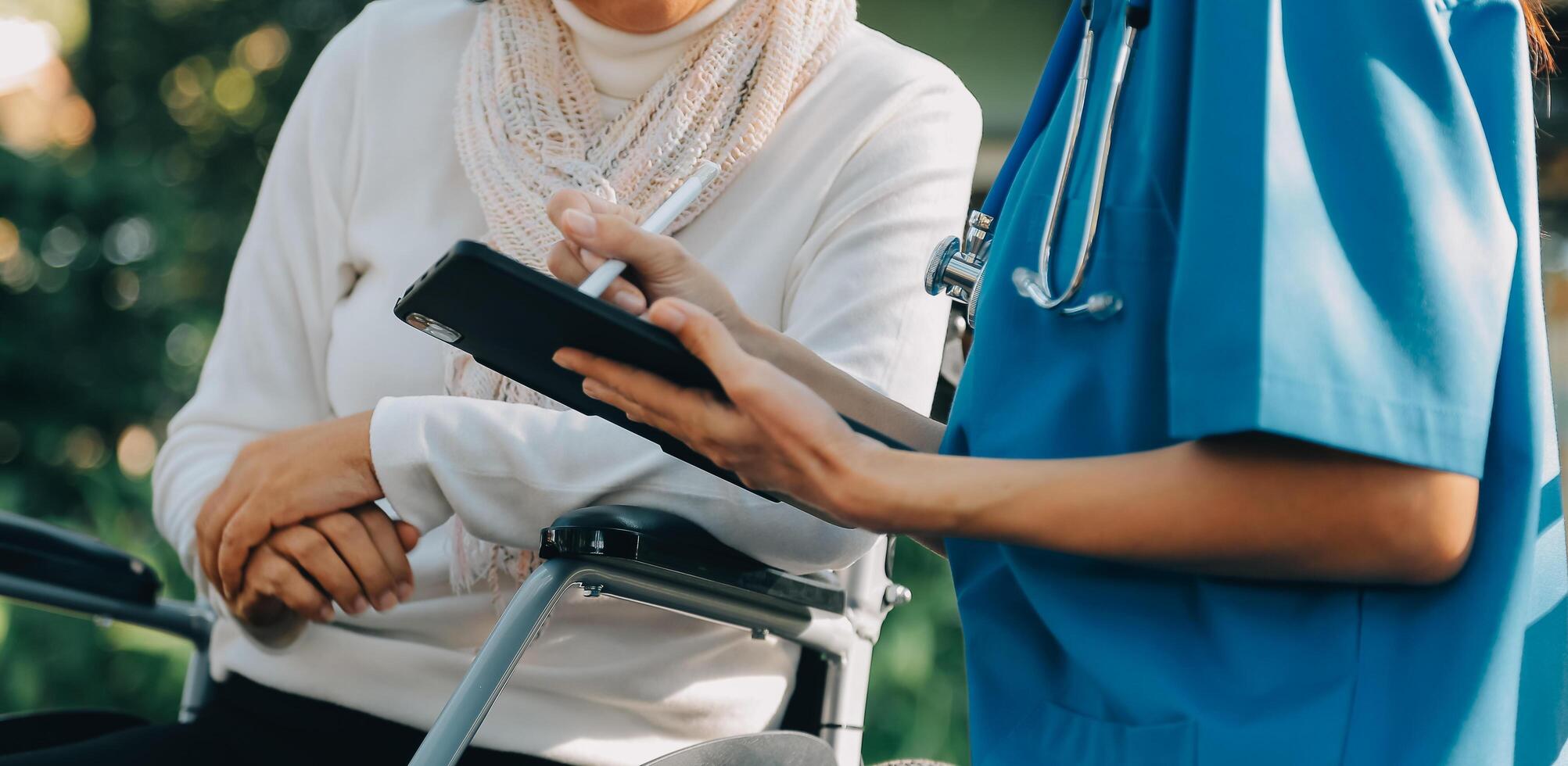 enfermagem funcionários falando para a idosos pessoa sentado dentro uma cadeira de rodas. foto