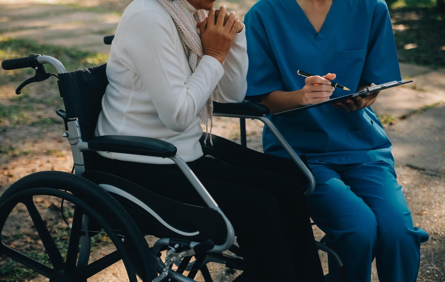 uma enfermeira levar Cuidado uma Senior masculino em cadeira de rodas dentro dele jardim às casa foto
