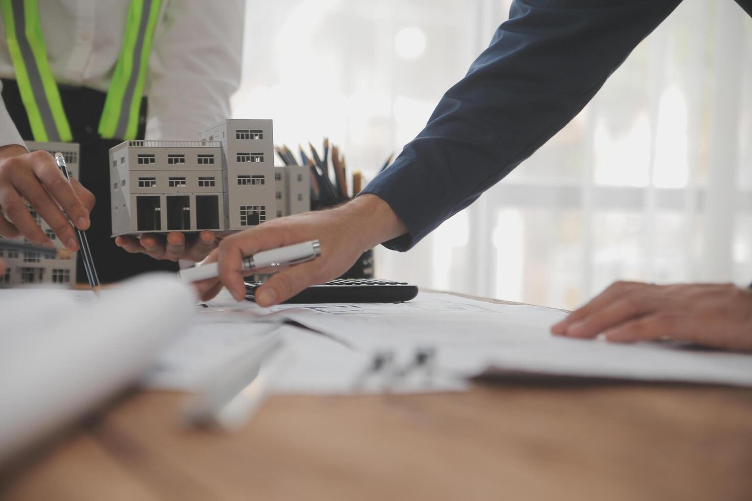 conceito de construção e estrutura de reunião de engenheiro ou arquiteto para projeto trabalhando com parceiros e ferramentas de engenharia na construção de modelo e projeto no local de trabalho, contrato para ambas as empresas. foto