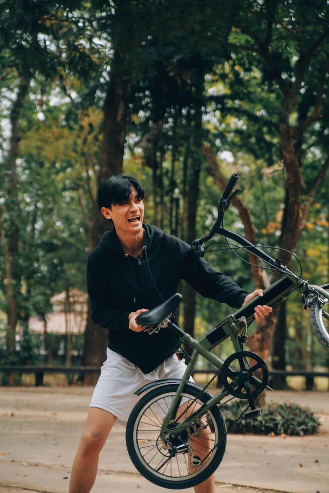 bonito feliz jovem homem com bicicleta em uma cidade rua, ativo estilo de vida, pessoas conceito foto