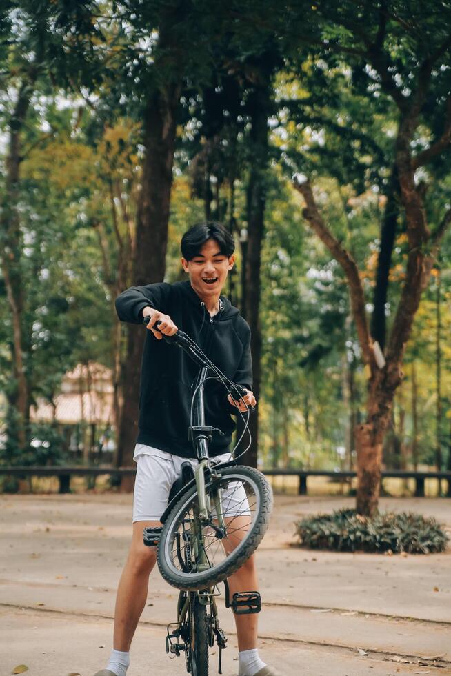 bonito feliz jovem homem com bicicleta em uma cidade rua, ativo estilo de vida, pessoas conceito foto