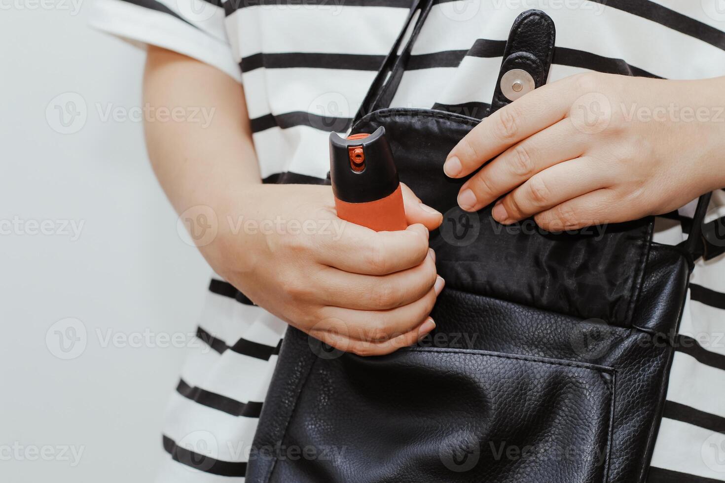 a menina coloca Pimenta spray dentro dela bolsa, a conceito do roubo, Perigo ou proteção foto