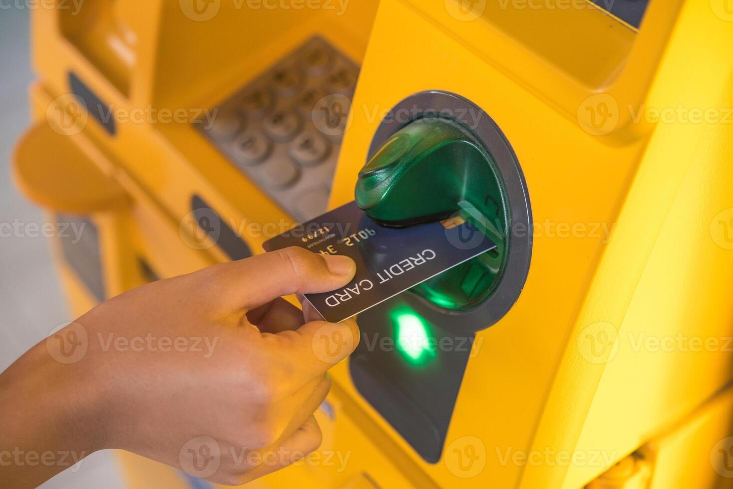 mão inserindo com uma crédito cartão para dentro banco máquina . homem usando a atm máquina com crédito cartão para retirar dinheiro foto