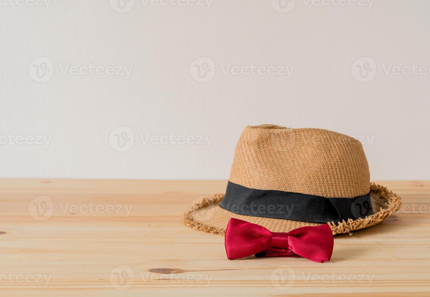 chapéu e vermelho gravata-borboleta estão colocada em de madeira chão. foto