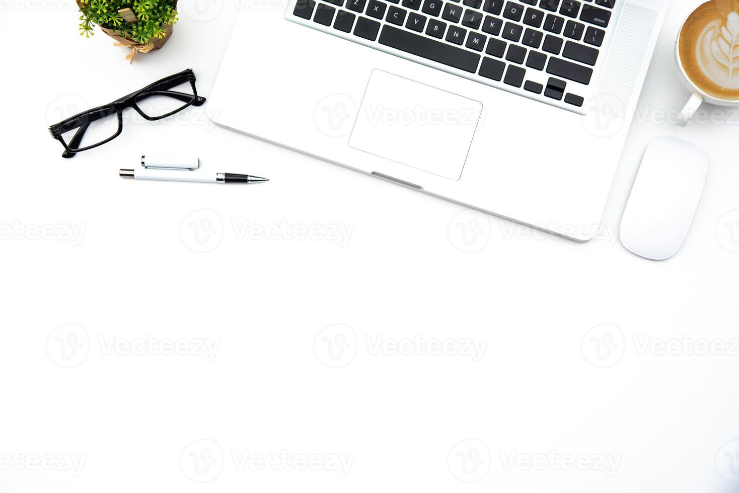 topo Visão com trabalhando escrivaninha com laptop, celular, notebook lápis café copo e Óculos dentro a escritório. foto