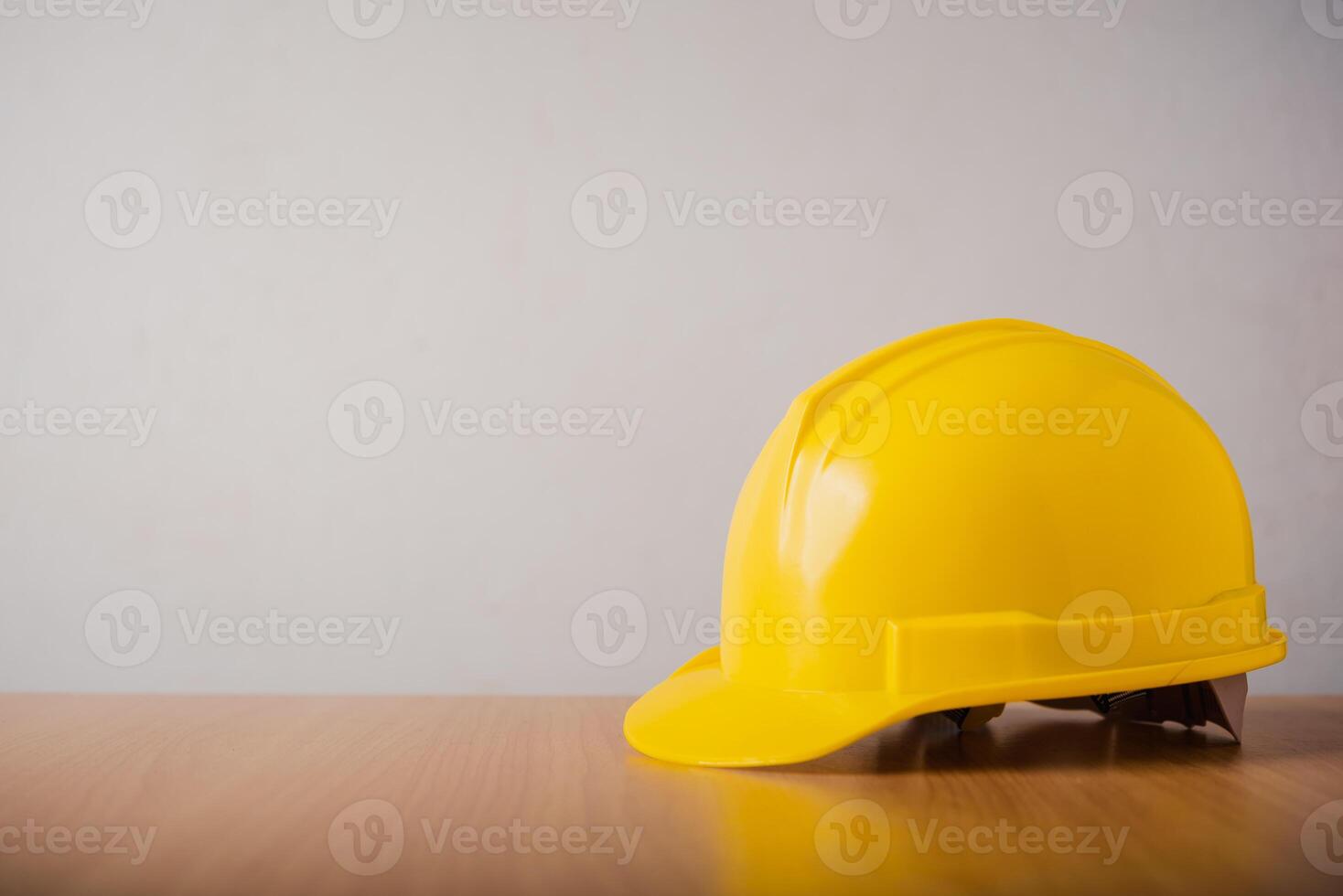 amarelo Difícil chapéu segurança capacete em madeira fundo foto