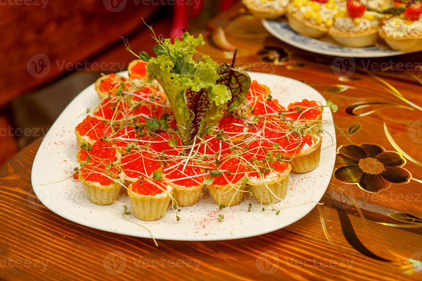 tortinhas com coalhada queijo e vermelho caviar decorado com ervas em uma prato foto