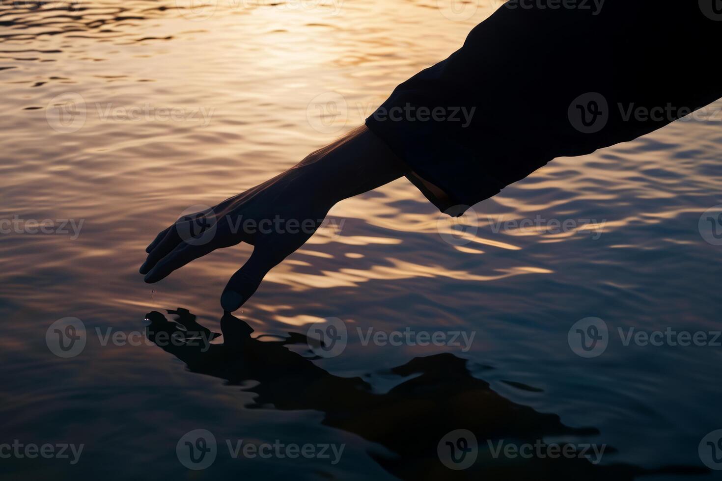 ai gerado fêmea mão tocante a calma oceano lago água superfície refletindo uma lindo colorida verão pôr do sol foto