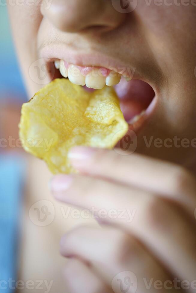 irreconhecível Adolescência menina comendo crocante batata lasca foto