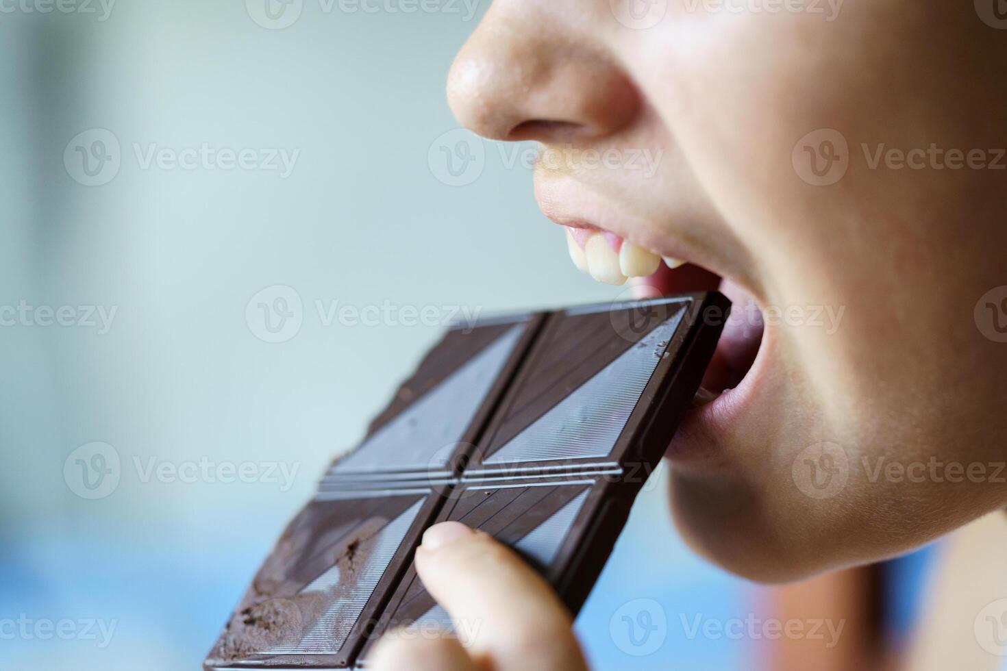 anônimo menina com boca aberto comendo chocolate Barra às casa foto