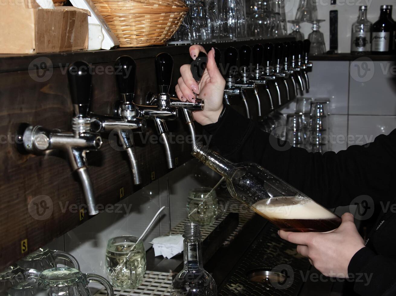 atrás a contador. mulheres mãos belas e facilmente derramar Cerveja para dentro uma garrafa. foto