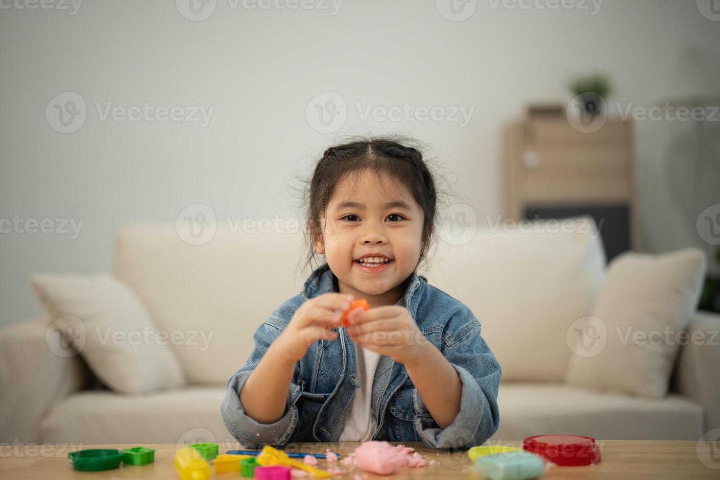 ásia fofa pequeno menina Aprendendo e jogando para usar colorida jogar massa dentro a vivo quarto às a lar. bebê atividade Educação desenvolvimento estilo de vida conceito. foto