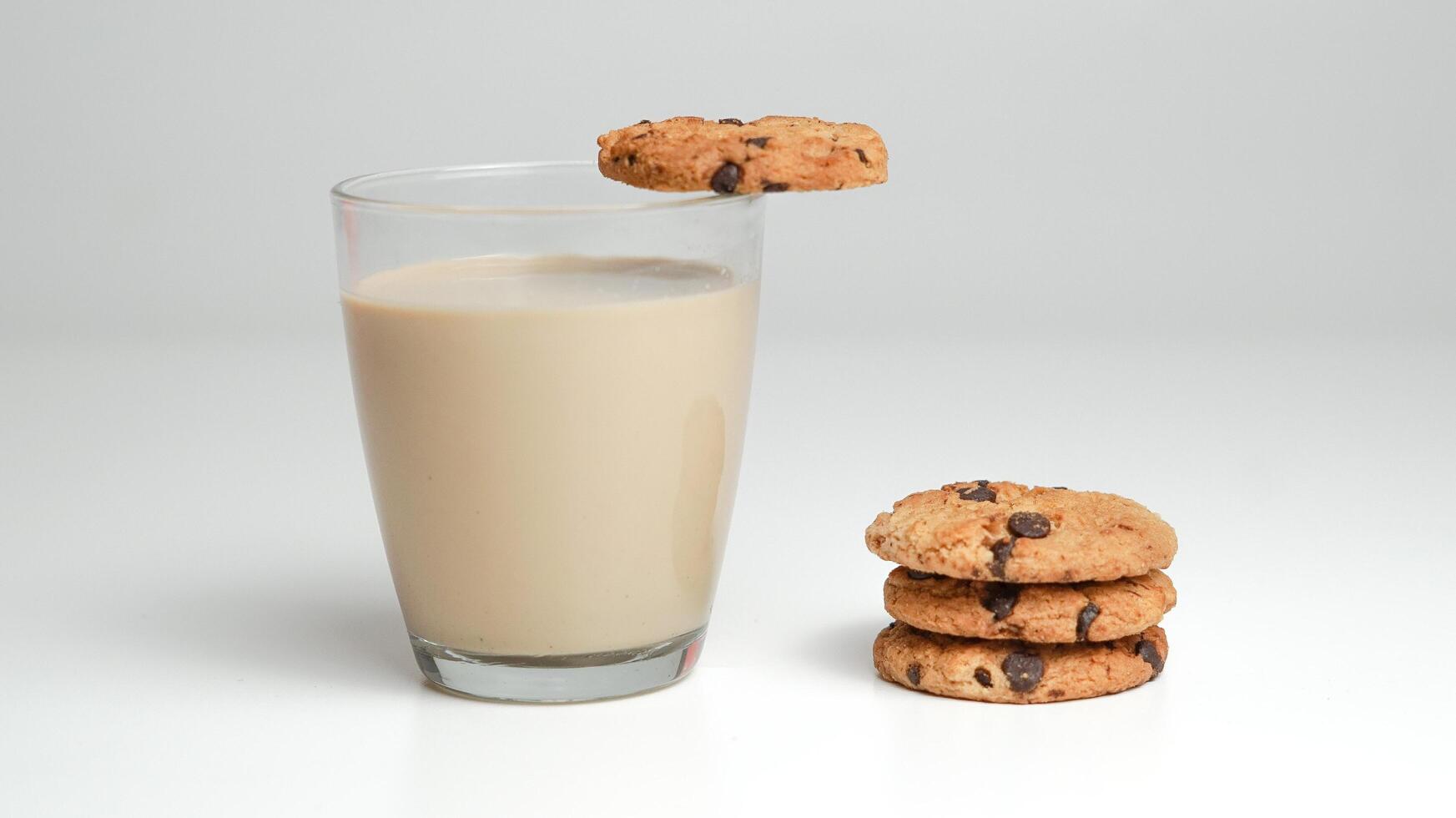 chocolate lasca biscoitos e uma vidro do leite café em uma branco fundo foto