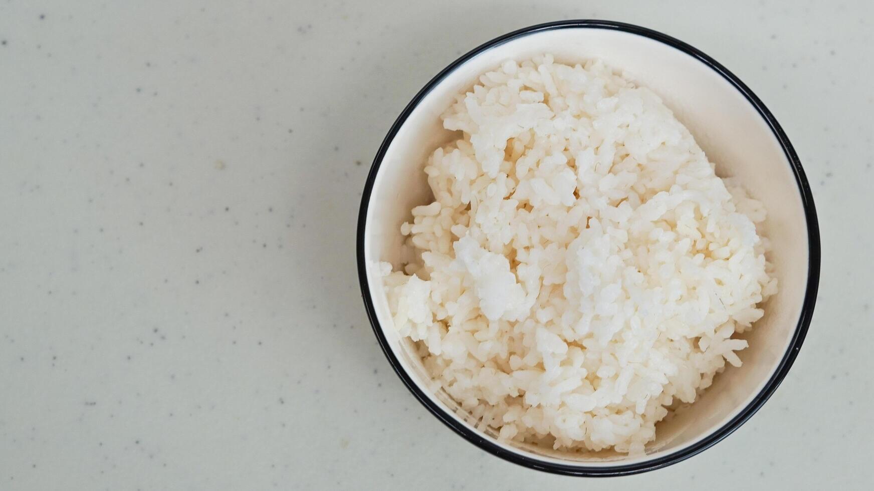 branco arroz dentro uma branco tigela com pauzinhos foto