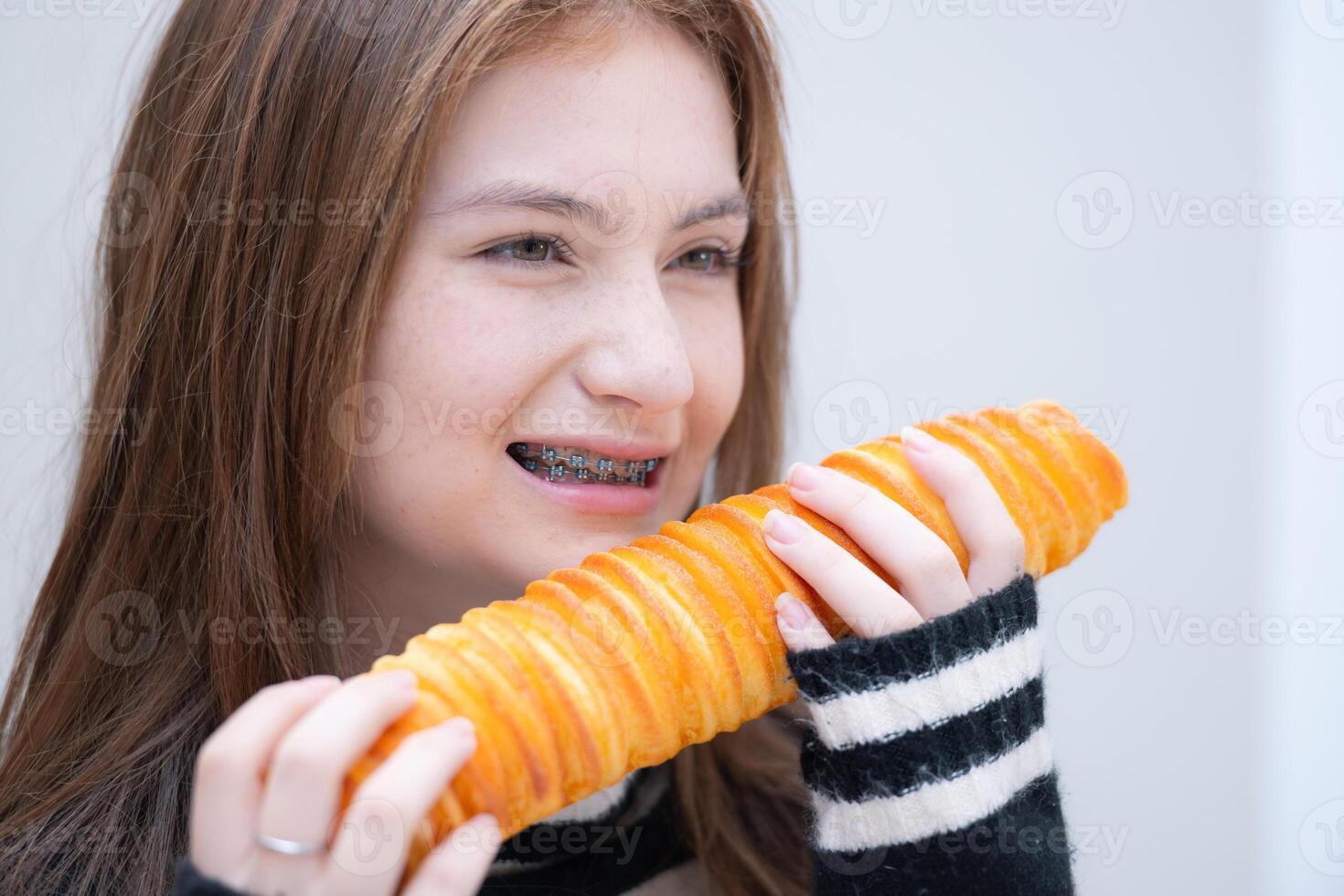 retrato do Adolescência menina comendo pão dentro a cozinha às casa foto