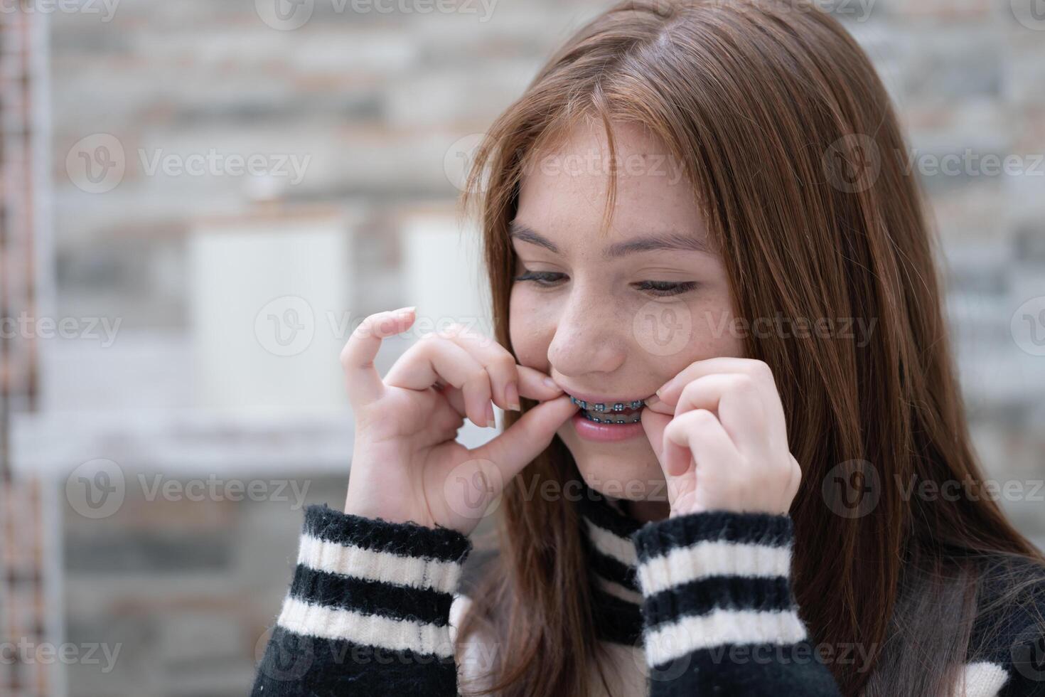 retrato do Adolescência meninas com suspensórios em dela dentes foto