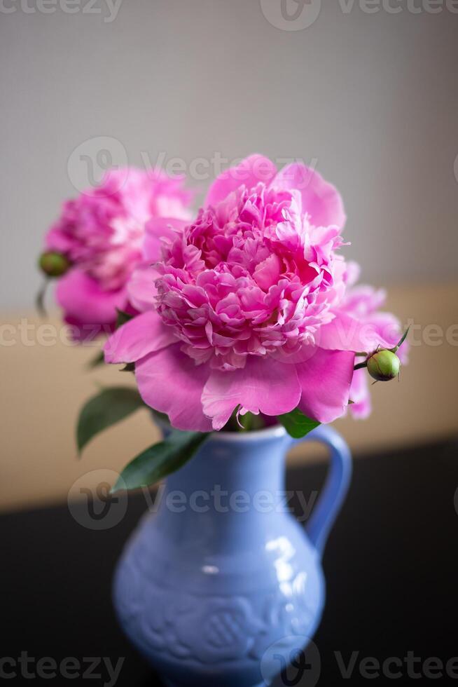 lindo fresco Rosa peônias dentro uma barro azul jarro foto