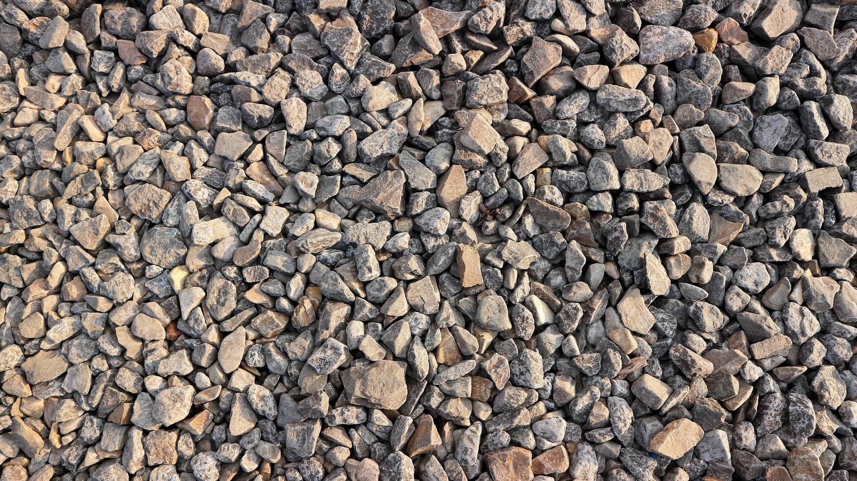 pequeno estrada pedra fundo, Sombrio cascalho textura, pedra seixos, desatado textura. Ferrovia cascalho. foto
